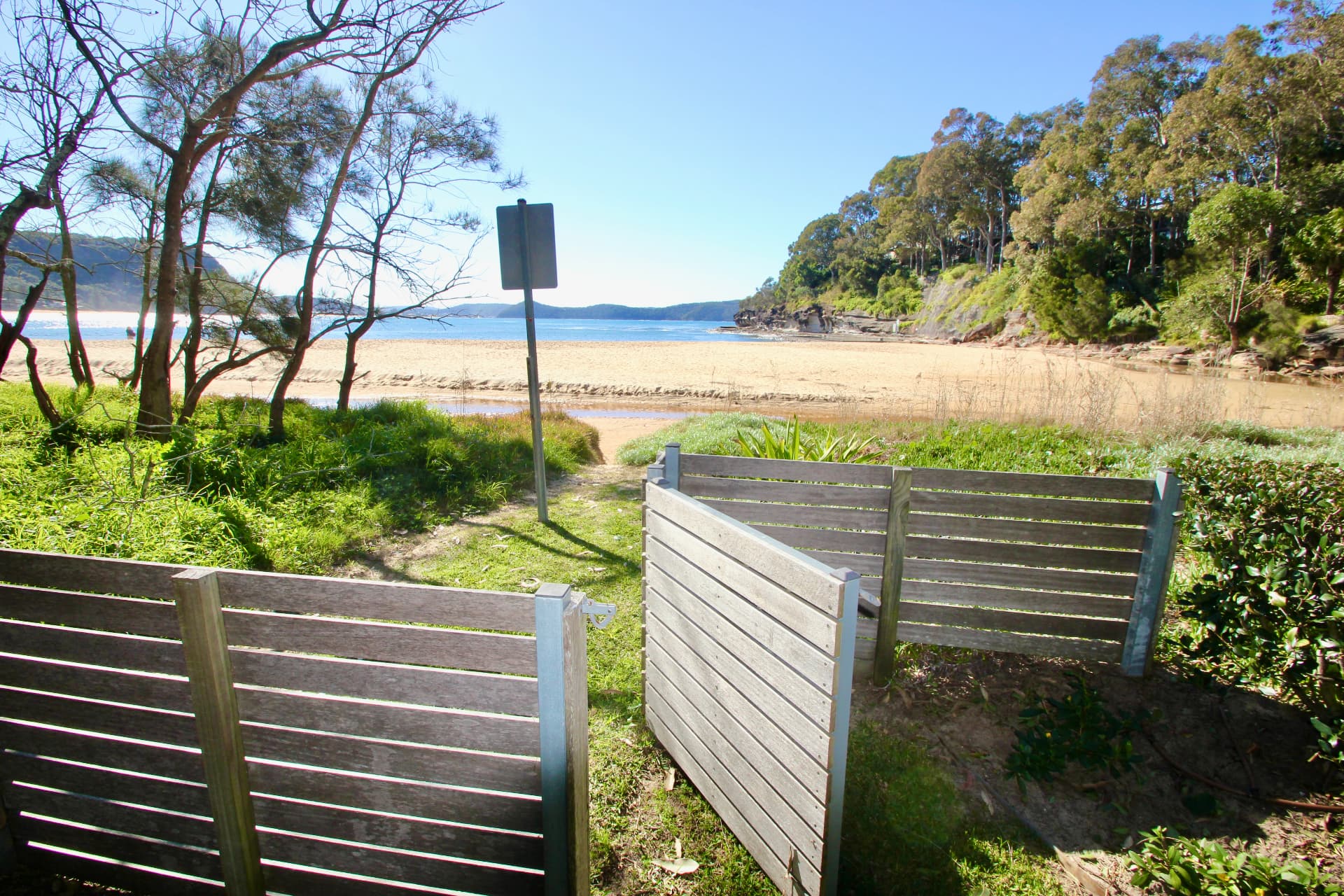 Timber back gate of The Gem opening straight onto the Pearl Beach lagoon, sand and water