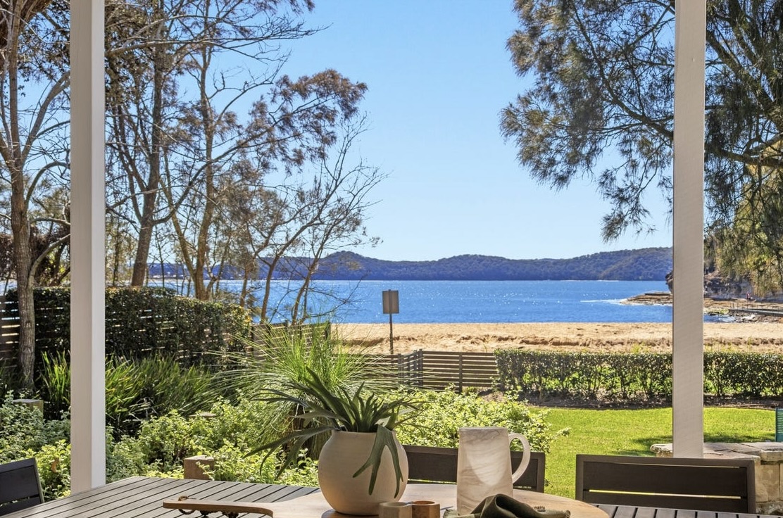 Framed view of Pearl Beach and Broken Bay from the downstairs terrace dining table